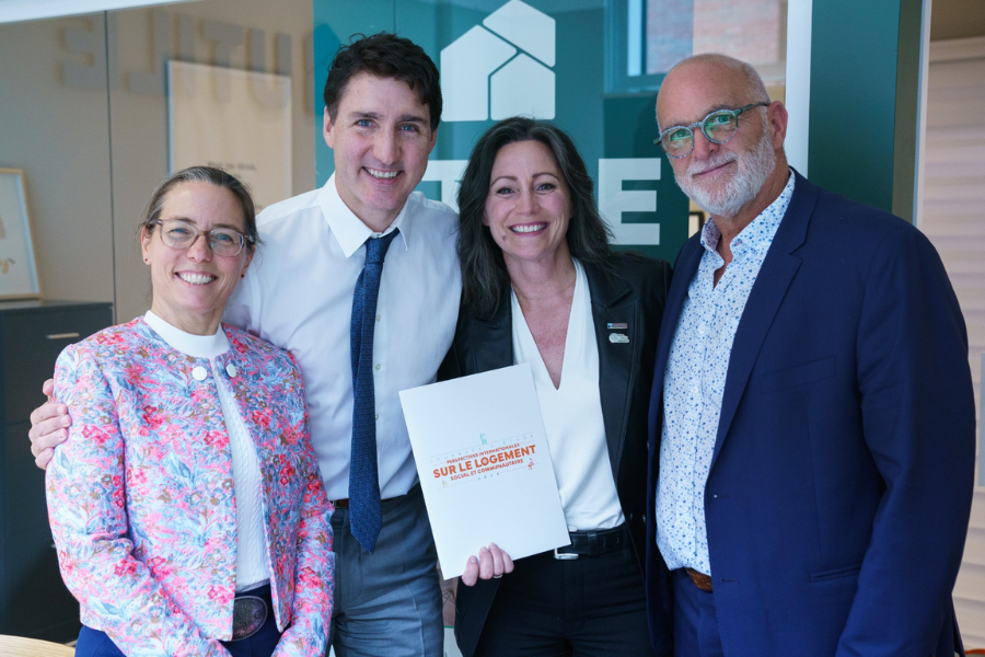 Sandra Turgeon (CQCH), Justin Trudeau, premier ministre du Canada, Annie Coulome et Michel Côté (FROHCQ) avec la pochette des Journées d'étude sur le logement social et communautaire